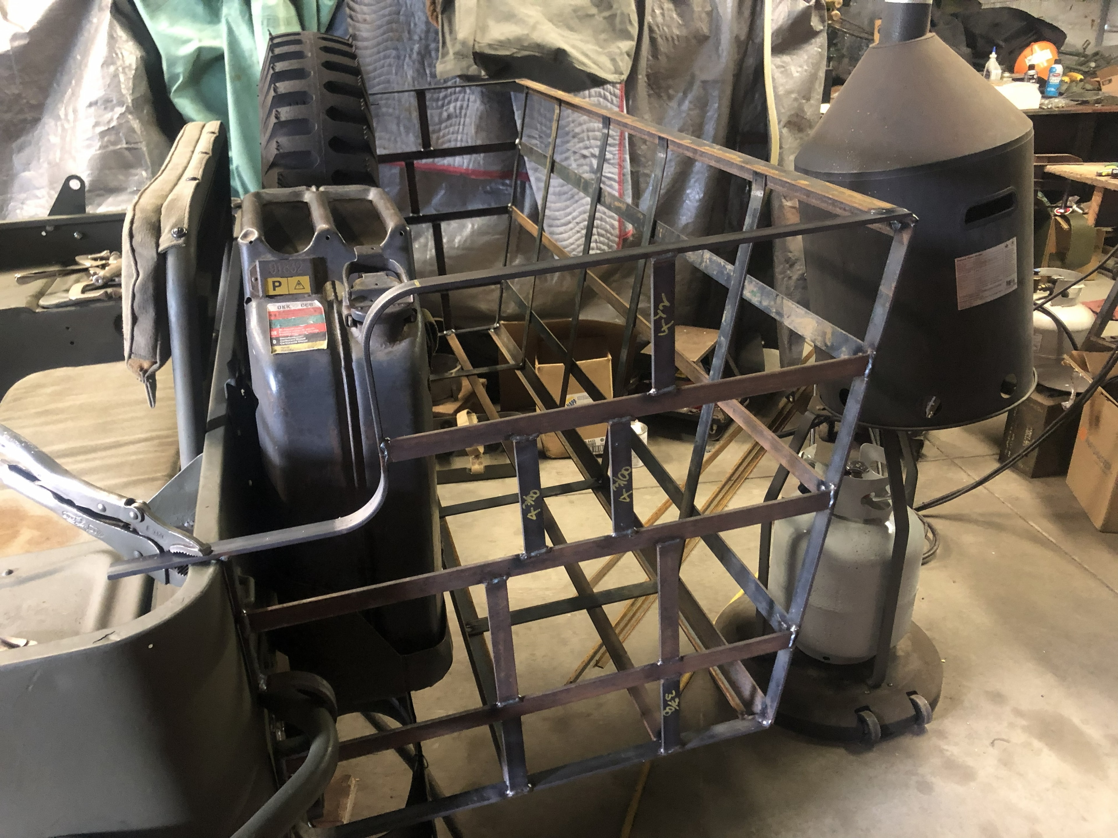 Bustle rack being fitted to rear of military vehicle in workshop